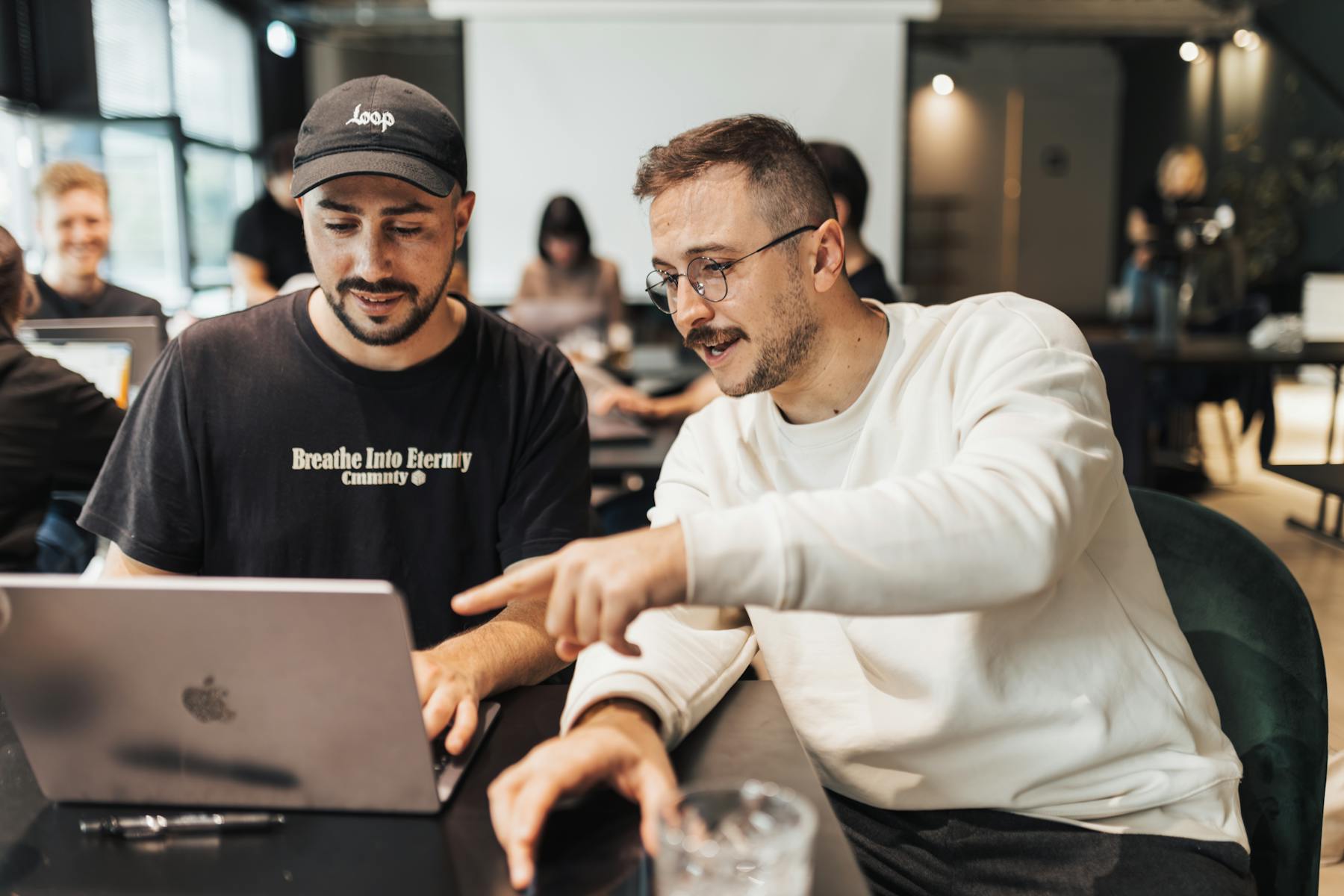 Twee ondernemers bespreken een websiteaanvraag aan een laptop