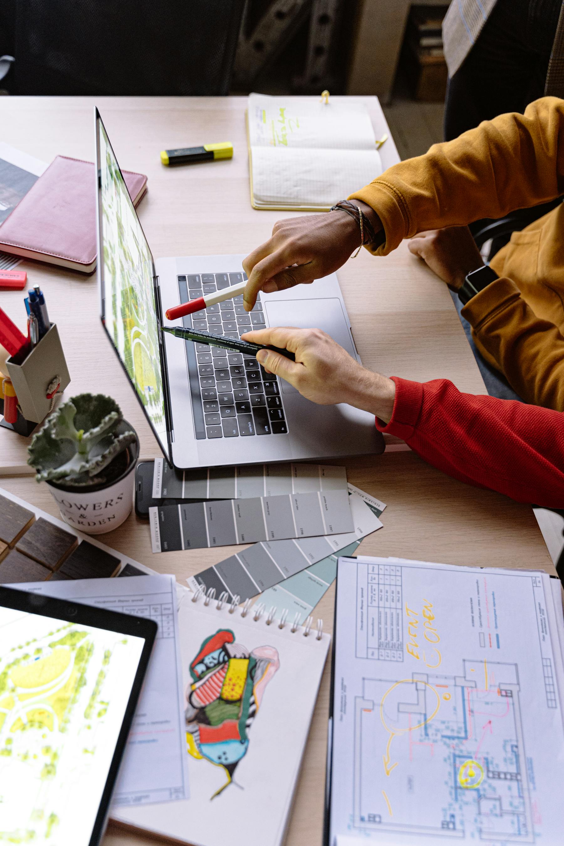 Websiteontwerp wordt besproken aan een laptop met notities op tafel